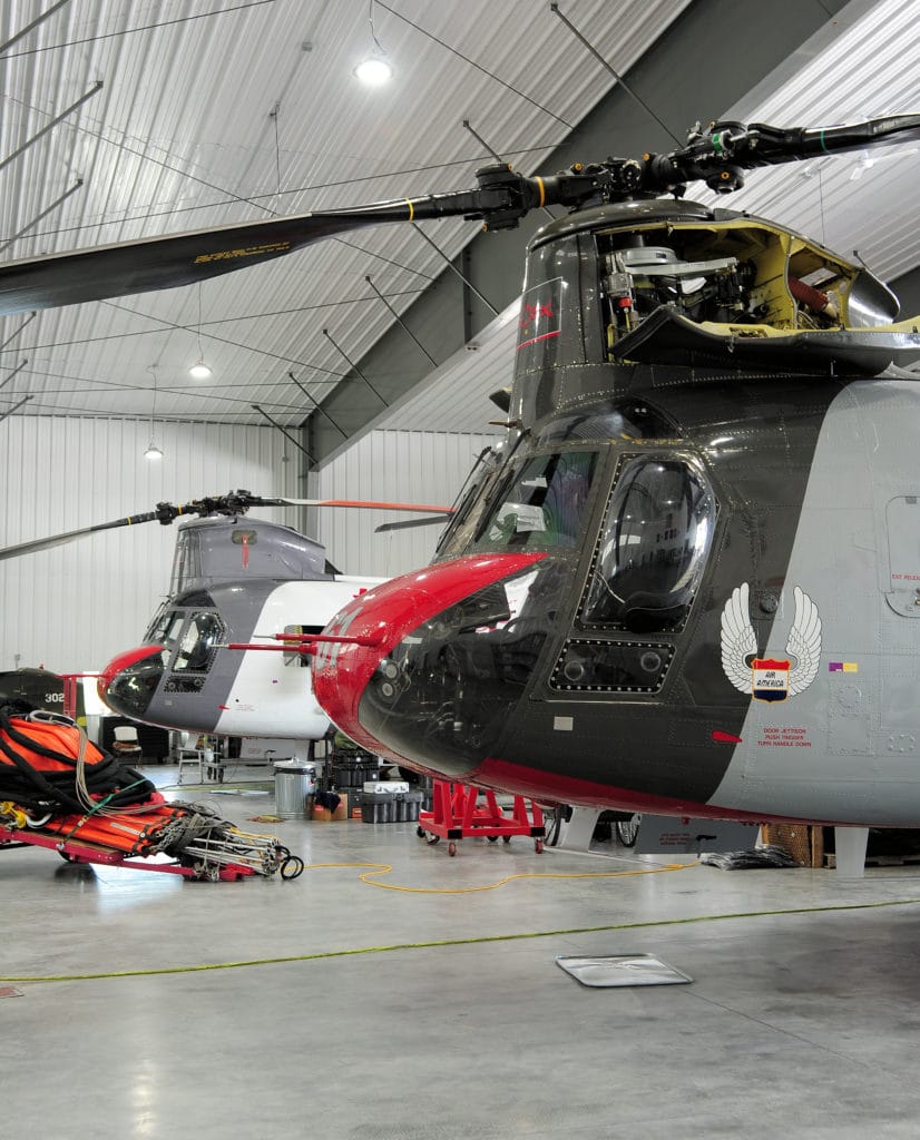 Chinooks in hanger being serviced by crew