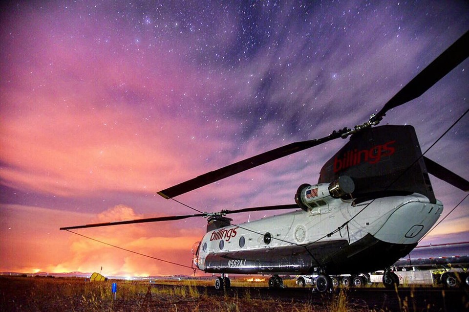 CH-47D at dusk with wildfire in distance